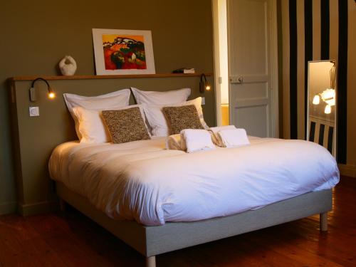 a large bed with white sheets and pillows at Domaine du cloitre in Pléneuf-Val-André