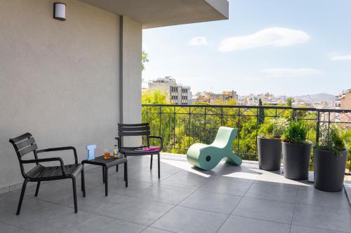 a balcony with chairs and tables on a balcony at Fits Living in Athens