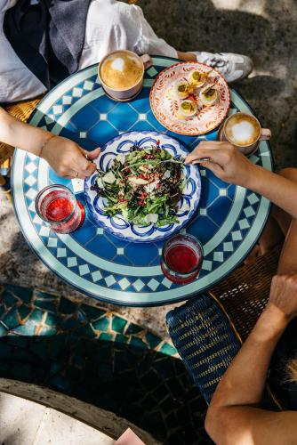 a group of people sitting around a table with plates of food at Hotel Granada, a Design Hotel in Atlanta