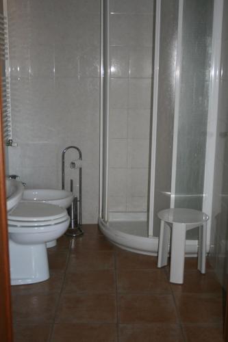 a bathroom with a toilet and a shower and a sink at Poggio Picchio in Bibbona