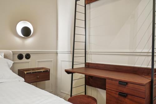 a bedroom with a ladder next to a bed and a desk at Hôtel Clémence in Paris