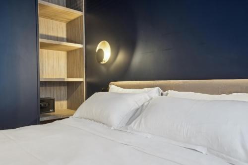 a bedroom with a bed with white pillows at Hôtel Clémence in Paris