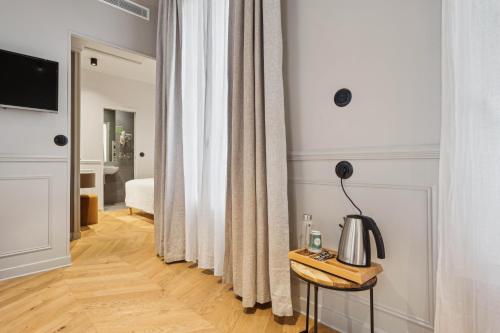 a room with a table with a lamp on it at Hôtel Clémence in Paris