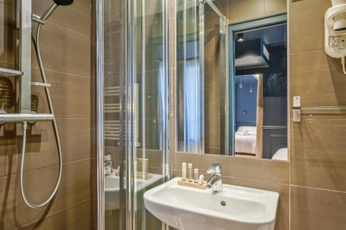 a bathroom with a sink and a shower at Hôtel Clémence in Paris