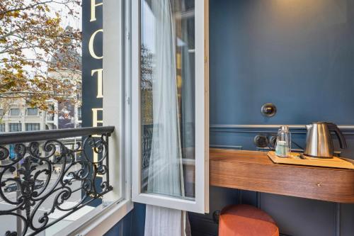 a balcony with a wooden table and a window at Hôtel Clémence in Paris