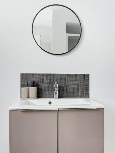 une salle de bain avec un lavabo blanc et un miroir dans l'établissement Le d'Alembert - Joli T3 lumineux et spacieux, à Dijon