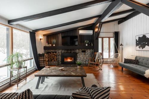 un salon avec un canapé et une cheminée dans l'établissement Le Cozy de St-Come - Lake front- boats, à Saint-Côme