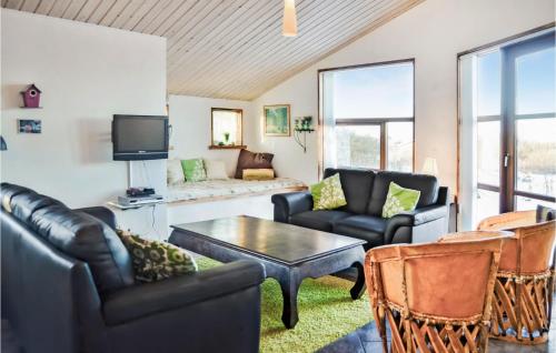 a living room with leather furniture and a tv at Holiday Home Hellesvej Vestervig Denm in Vestervig