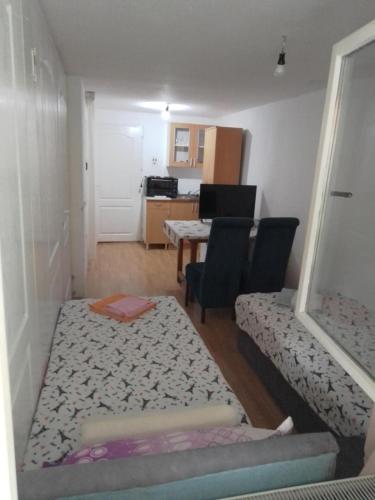 a small room with a bed and a table and chairs at Sobe za izdavanje Nedeljković in Lukovo