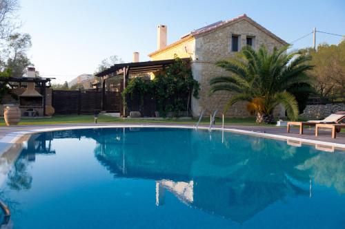 a large blue swimming pool in front of a house at 5 Stars Villas in Svoronata