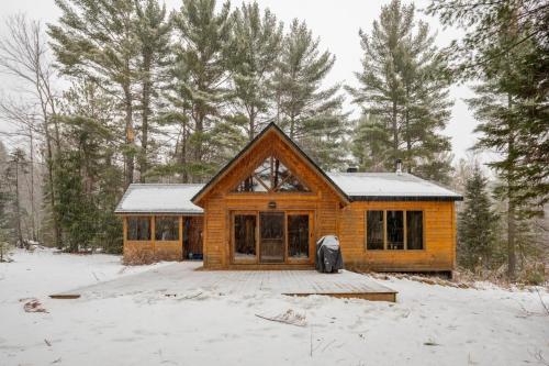 eine Blockhütte im Schnee mit Bäumen in der Unterkunft Zazz - For precious moments with family or friends in Chertsey