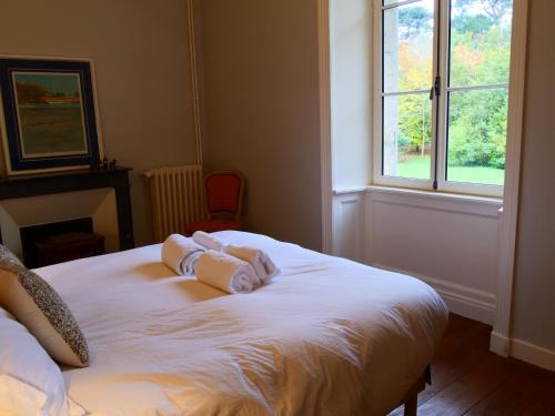 a bedroom with a white bed with towels on it at Domaine du cloitre in Pléneuf-Val-André