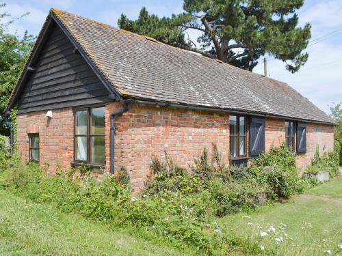 an old brick house with a slate roof at Stable Cottage in Ticehurst