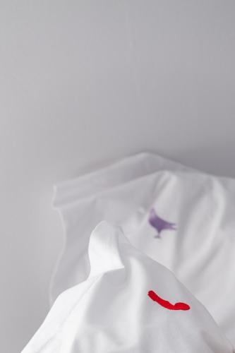 a white shirt with a red mark on it at Fits Living in Athens