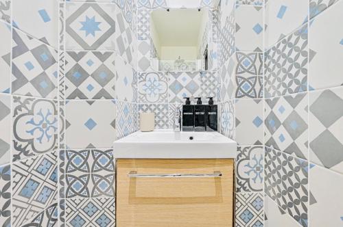 une salle de bain avec un lavabo et un miroir dans l'établissement Grand appartement Parc des princes Paris 16, à Paris