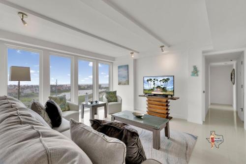 a living room with a couch and a tv at Bahia Mar-Solare Tower, Beachfront Resort with Two Pools in South Padre Island