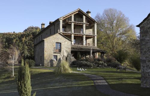 une ancienne maison en pierre sur un champ herbeux dans l'établissement Casa de San Martín, à San Martín De Solana