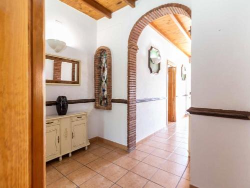 eine Küche mit Torbogen und Fliesenboden in der Unterkunft Villa Verde in Nigüelas