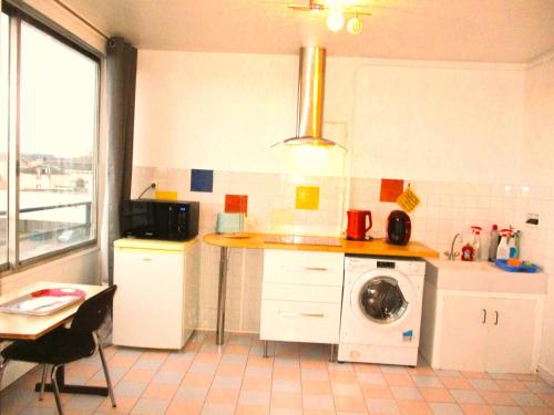 a kitchen with a washing machine and a counter at LIMOGES,LA vue, 7e ciel, ascenseur ! in Limoges