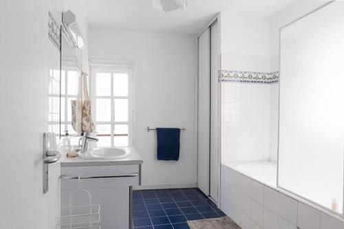 une salle de bain blanche avec un lavabo et une douche dans l'établissement Appartement Avignon du Château de Marrets, à Avignon