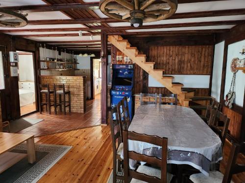 a dining room with a table and a staircase at Cabana Kris in Orlat