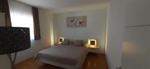 a bedroom with a bed with two lights on it at Apartment Bianca Mljet mit Meerblick in Okuklje