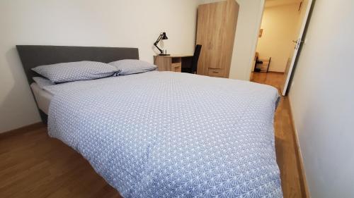 Una cama con un edredón azul en un dormitorio. en Center & River Park View Guesthouse, en Pančevo