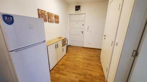 cocina con nevera y suelo de madera en Center & River Park View Guesthouse, en Pančevo