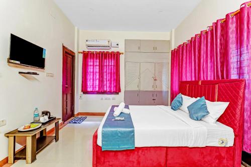 a bedroom with a large bed with pink curtains at Nexus Serviced Apartment Ramapuram in Chennai