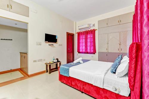 a bedroom with a large bed with red curtains at Nexus Serviced Apartment Ramapuram in Chennai