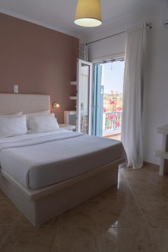 a bedroom with a large bed and a sliding glass door at Aggelos Studios in Adamas