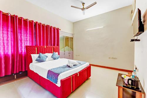 a red bed in a room with red curtains at Nexus Serviced Apartment Ramapuram in Chennai
