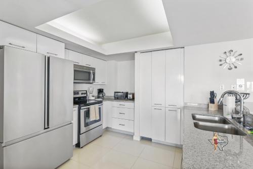 a kitchen with white cabinets and stainless steel appliances at Bahia Mar-Solare Tower, Beachfront Resort with Two Pools in South Padre Island