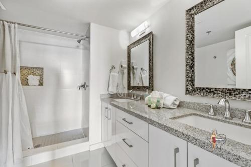 a white bathroom with a sink and a mirror at Bahia Mar-Solare Tower, Beachfront Resort with Two Pools in South Padre Island