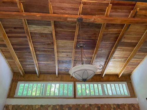 a ceiling with wooden beams and a chandelier at Papaya Wildlife Lodge in Cahuita
