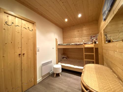 - une chambre avec des murs en bois et des lits superposés dans l'établissement Courchevel 1850 - 4 personnes - ski aux pieds - wifi gratuit, à Courchevel