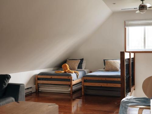 a room with two beds with a stuffed animal on them at Le Lac Apaisant - Rustic Haven by the Water in Saint-Calixte