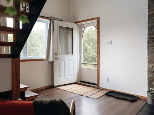 an empty room with a door and a window at Le Lac Apaisant - Rustic Haven by the Water in Saint-Calixte