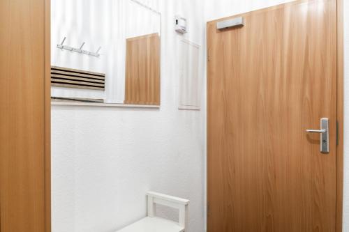 a bathroom with a toilet and a wooden door at SchaeBu! 1 Ferienwohnung im Herzen von Cottbus in Cottbus
