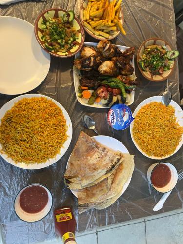 a table with many plates of food on it at Camille WadiRum Camp in Disah