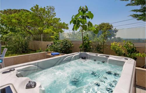 a jacuzzi tub in a backyard with trees at 1 Bedroom Awesome Home In Rab in Rab