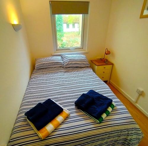 a bedroom with a bed with two towels on it at Woodland View - Families & Pets in Uny Lelant
