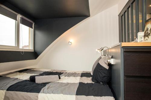 - une chambre noire et blanche avec un lit dans l'établissement Little Suite - Romain, à Lille