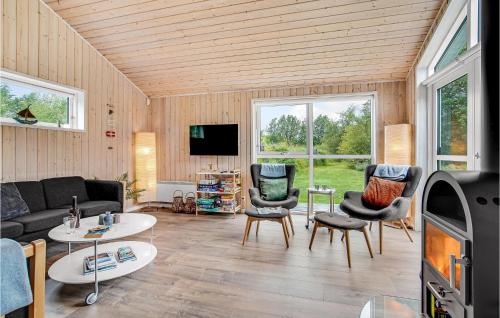 a living room with a couch and chairs and a tv at Cozy Home In Ålbæk With Kitchen in Ålbæk
