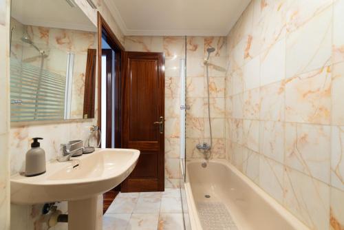 a bathroom with a sink and a bath tub at Suite Deluxe By Princesa con Parking in Vigo