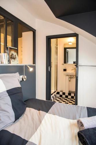 - une chambre avec un lit et une salle de bains avec un miroir dans l'établissement Little Suite - Romain, à Lille
