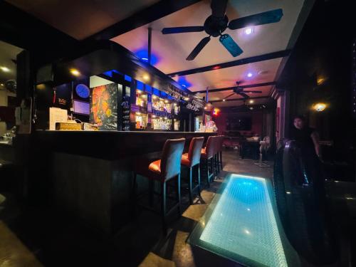 a bar with chairs and a bar with blue lights at Baipho Lifestyle in Patong Beach