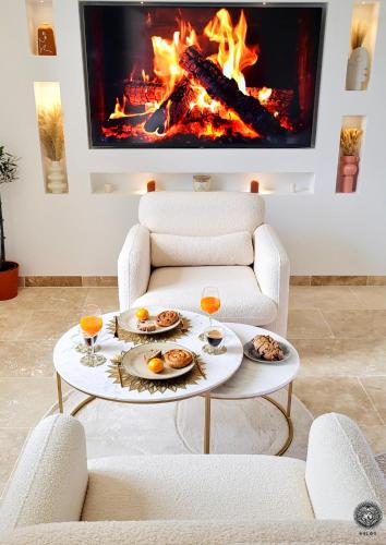 - un salon avec une cheminée et une table avec de la nourriture dans l'établissement - LA SUITE DELOS - JACUZZI 2 PLACES - CENTRE VILLE A PIED - LIT QUEEN SIZE - PARKING PRIVÉE - WIFI - City Center within walking distance -, à Quimper