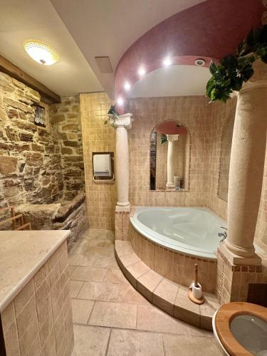 La grande salle de bains est pourvue d'une baignoire et d'un miroir. dans l'établissement Loustalet, à Saint-Jean-de-la-Blaquière