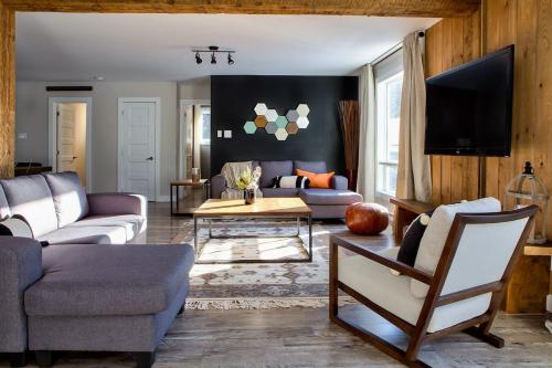 Entre Monts et Lac - lac - Lake front & Volleyball في Saint Adolphe D'Howard: غرفة معيشة بها أريكة وطاولة